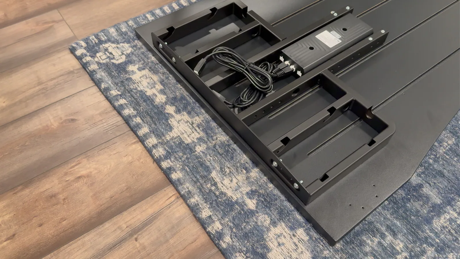 UPLIFT V3 4-Leg frame and control box mounted beneath the black desktop before the legs are installed