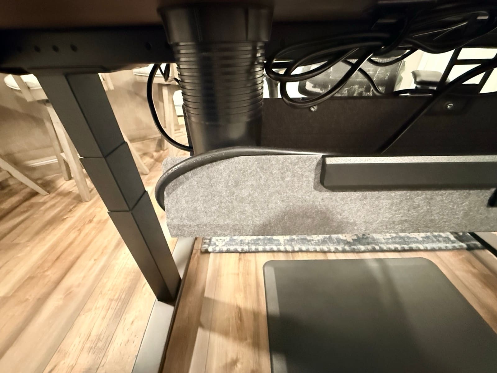 Under-desk view of the V3 showing the FlexMount cable tray, routed cables, and walking pad