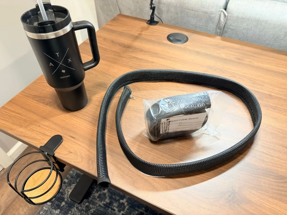 Cable sleeve installed under a desk, bundling the run off the desktop.